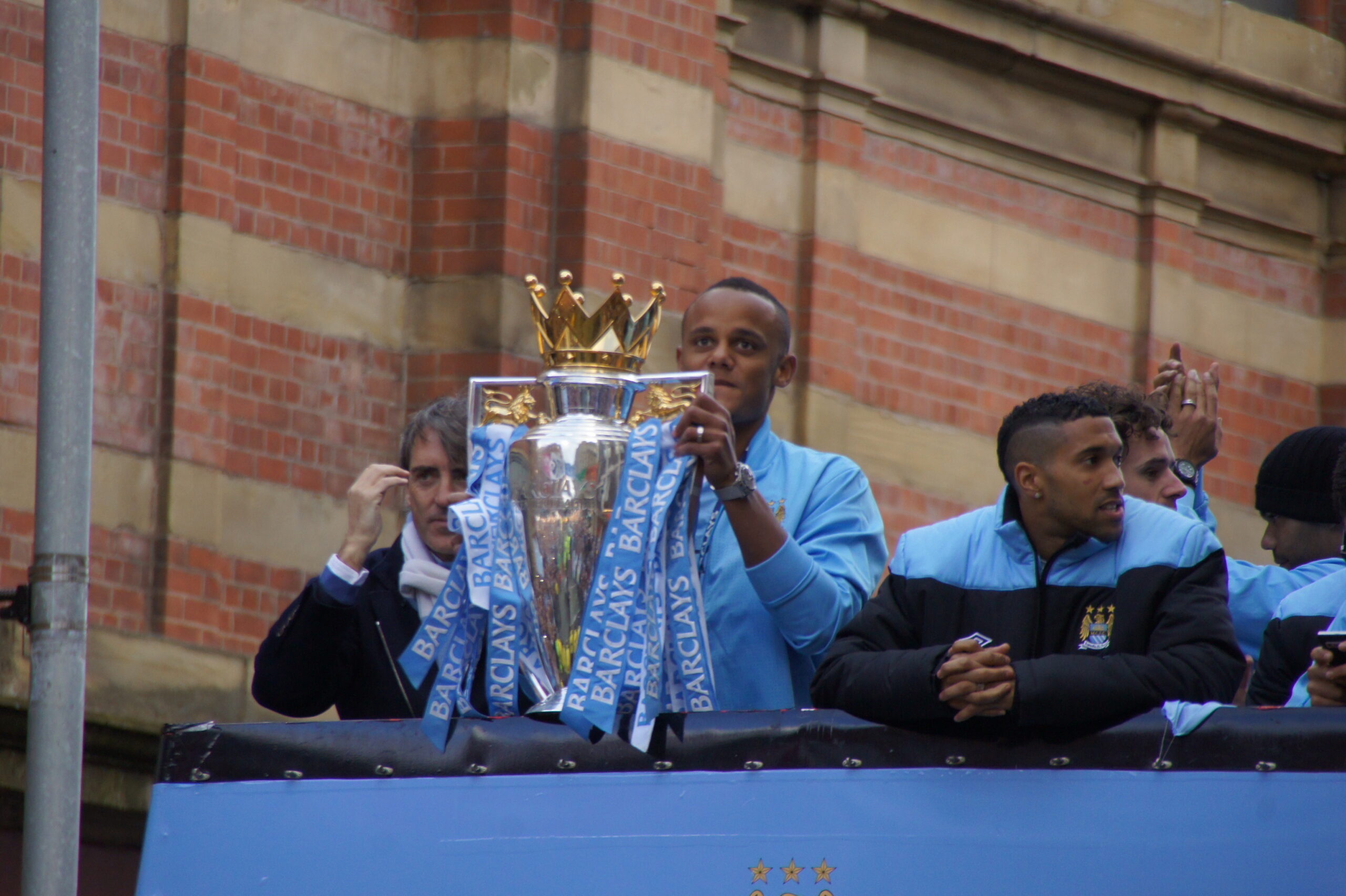Manchester City player holding the Premier League trophy during the 2011–12 title parade